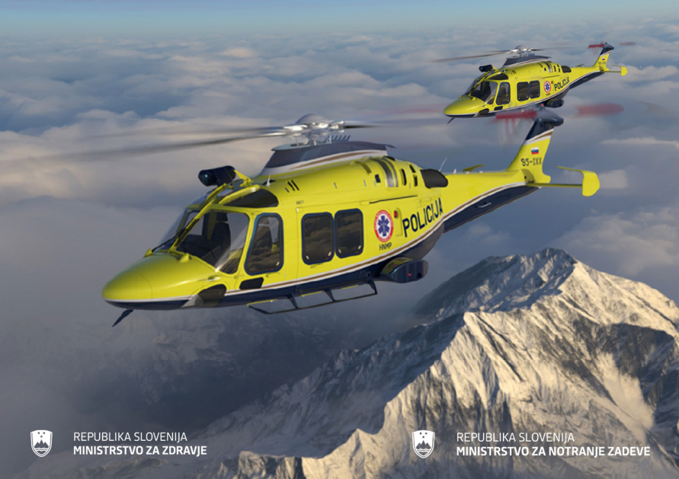 Dva rumena helikopterja, eden bližje, sta v zraku, napis policija in oznaka nmp, spodaj gore in zadaj oblaki.