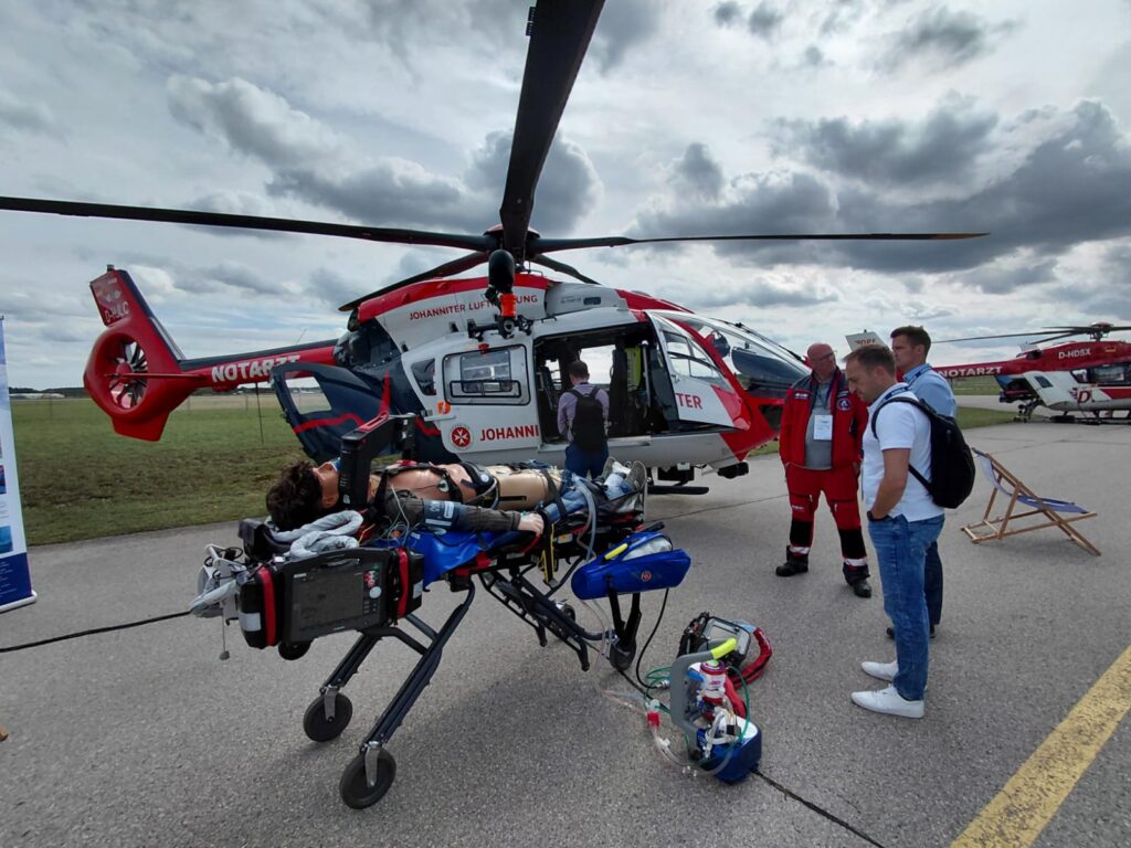 lutka pacient, reševalske aparature, ljudje pred helikopterjem